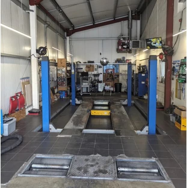 The MOT bay at Dellers Garage — the four-post lift and the brake roller tester in the floor